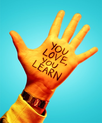 Photo with YOU LOVE, YOU LEARN written on the palm